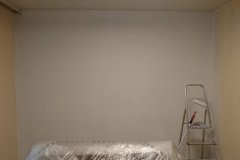Die erste Wand ist verspachtelt und weiß gestrichen
